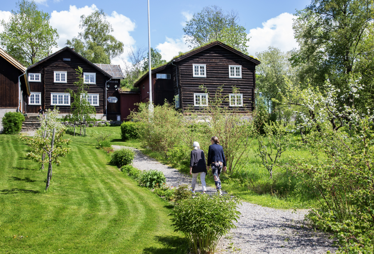 Gjester går på grusgang i hagen på Bjerkebæk.